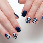 Cream pattern on two nails of each hand.