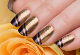 Gold nails with purple stripes.